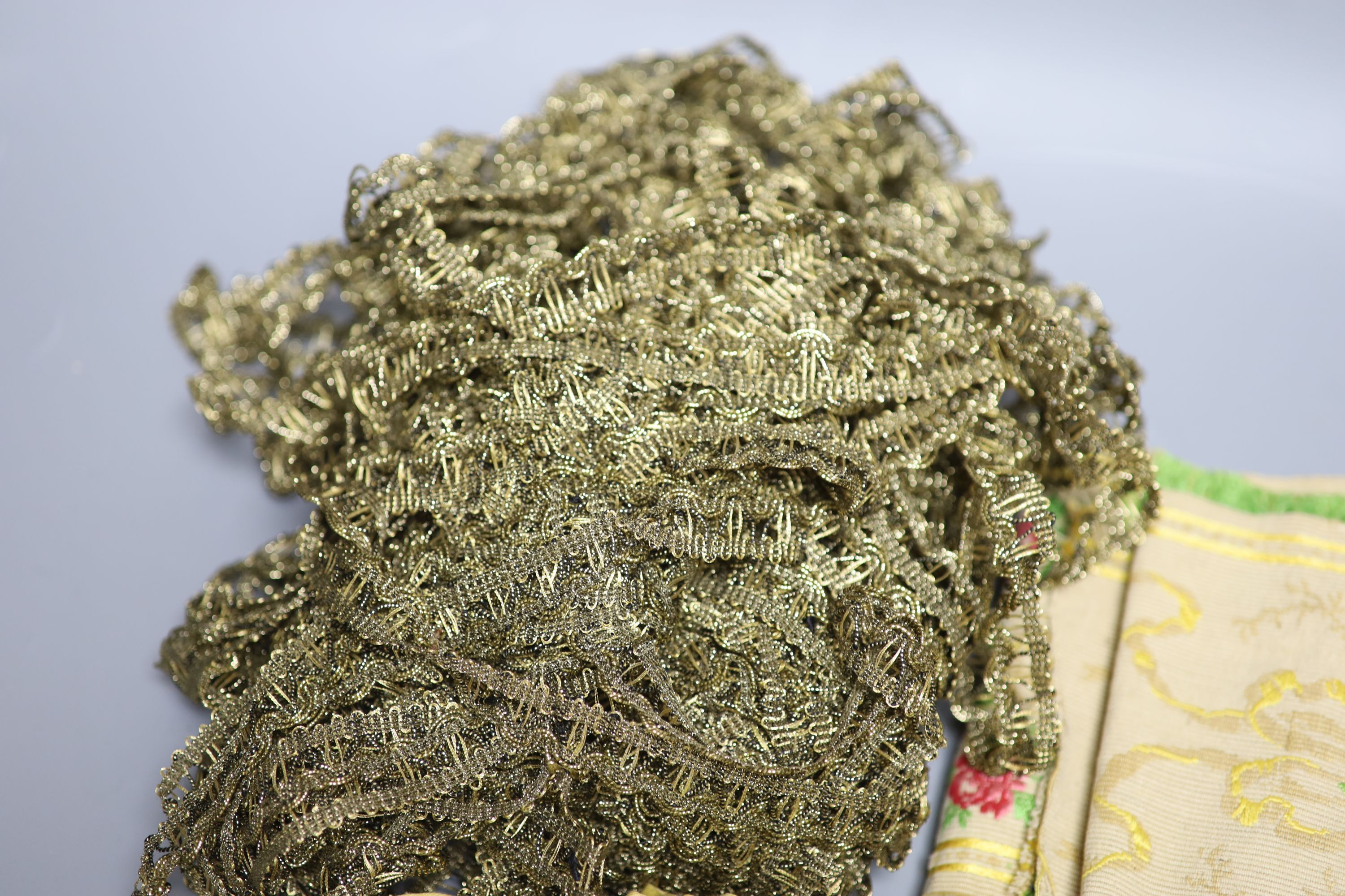 A Lurex 19th century cross stitch pelmet with gold coloured metal bullion fringing, a long French floral braid and a quantity of gold c